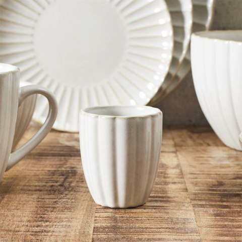 Beżowy ceramiczny kubek japandi Beju Magu I z pionowym ryflowaniem stojący na rustykalnym drewnianym stole.
