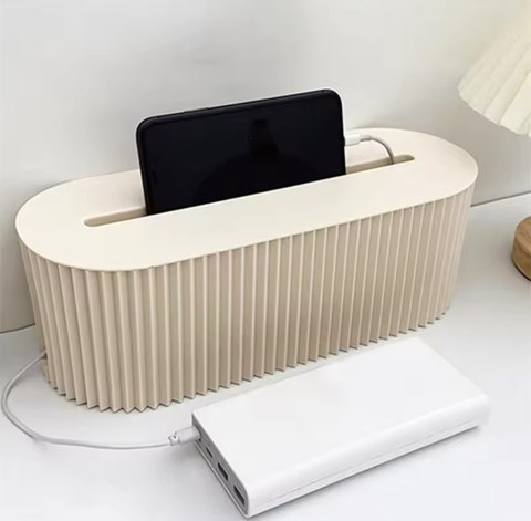 Organizer na kable Kaba ze smartfonem opartym w szczelinie pokrywy i podłączonym powerbankiem.